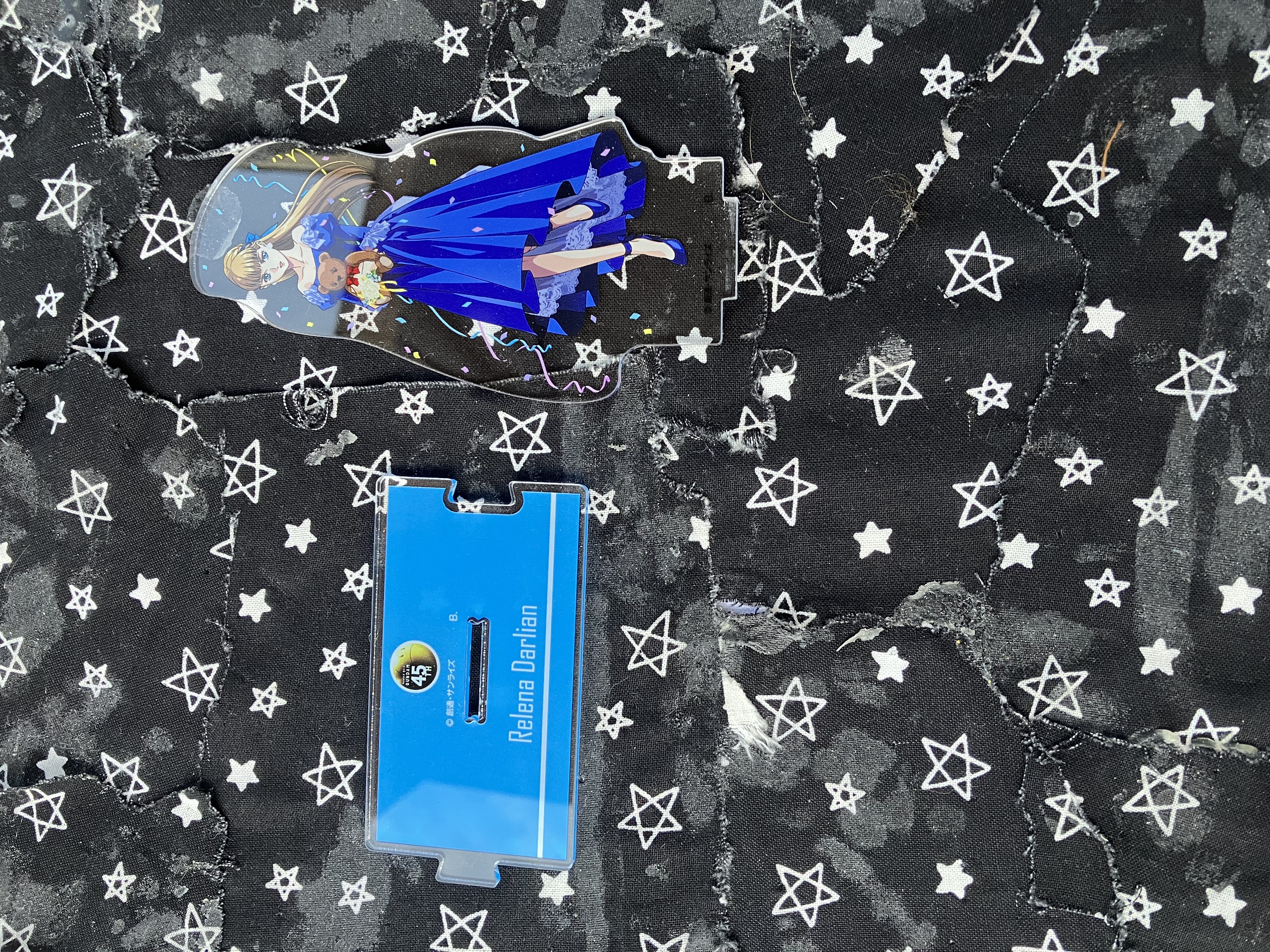 30th anniversary acrylic stand of Gundam wing Relena in a blue dress holding a teddy bear.